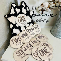 Cow print sign with milestone disc